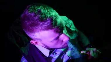 Shisha 'ların evinde nargileci bir adam. Ağır çekim. Yukarıdan görünüm