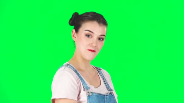 Girl coquettishly smiling while looking at camera on green screen. Slow motion — Stock Video