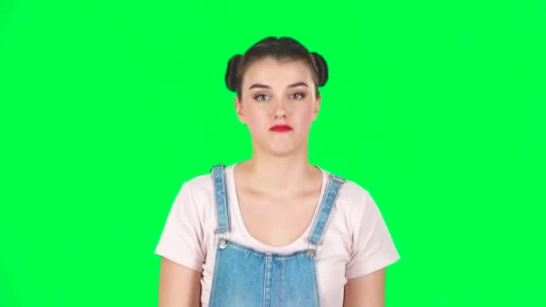 Забавная девушка позирует для камеры делает смешные лица на зеленом экране в студии, замедленная съемка — стоковое видео