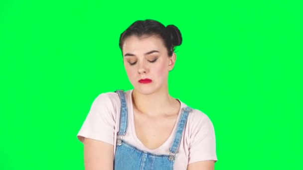 Chica se ve molesto en la cámara y se muerde los labios pantalla verde en el estudio, cámara lenta . — Vídeo de stock