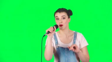 Çekici kız mikrofona şarkı söyler ve müziğin ritmine göre hareket eder, ağır çekimde.