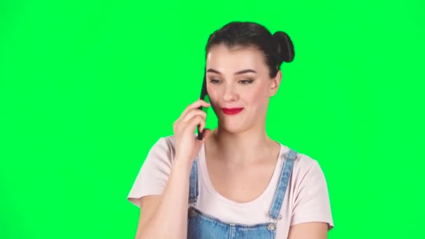 Uśmiechnięta dziewczyna mówi do telefonu komórkowego i cieszyć się na zielonym ekranie, zwolnione tempo — Wideo stockowe
