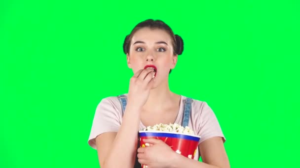 Sweet girl chews popcorn while watching a movie. Girl watching with spellbound, slow motion — 图库视频影像