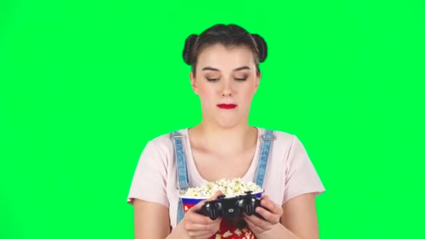 Video oyunu oynayan ve yeşil ekranda patlamış mısır çiğneyen bir kız. — Stok video