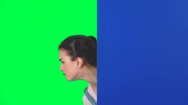 Дівчина дивиться ззаду блакитного порожнього плакату і закликає до себе вказуючий огорожу, повільний рух — стокове відео