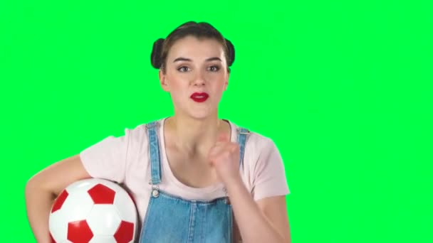 Dívka s fotbalovým míčem, na zdraví pro svůj oblíbený tým při sledování zápasu pak zklamaný na zelené obrazovce ve studiu, zpomalený film. — Stock video