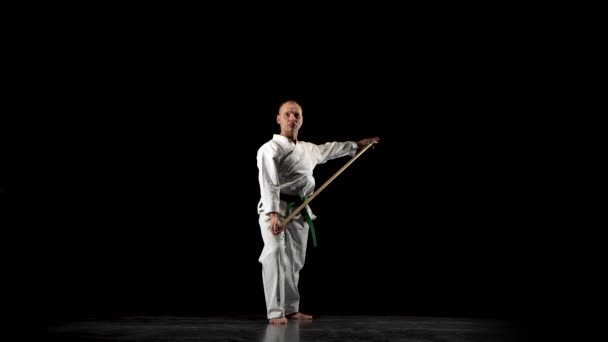 Борці кендо на білому кімоно практикують бойове мистецтво з бамбуковим боккеном на чорному тлі.. — стокове відео