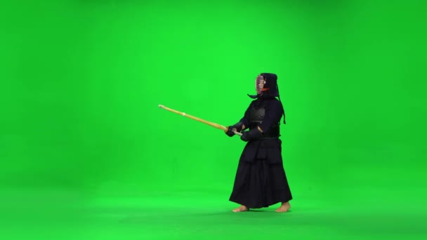 Masculine Kendo warrior practicing martial art with the bamboo bokken on green screen. — Stock Video