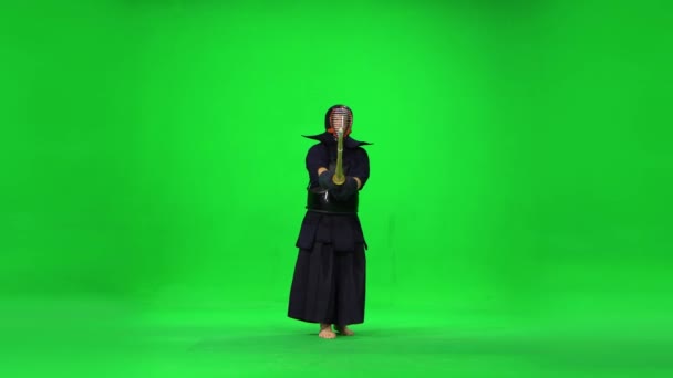 Männlicher Kendo-Krieger, der Kampfkunst mit dem Bambusbokken auf grünem Bildschirm praktiziert. — Stockvideo