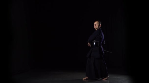 Kendo krijger beoefenen van krijgskunst met het Katana zwaard op zwarte achtergrond — Stockvideo