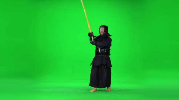 Männlicher Kendo-Krieger, der Kampfkunst mit dem Bambusbokken auf grünem Bildschirm praktiziert. — Stockvideo