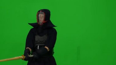 Erkek Kendo savaşçısı, yeşil ekranda bambu bokken ile dövüş sanatları yapıyor. Kapat.