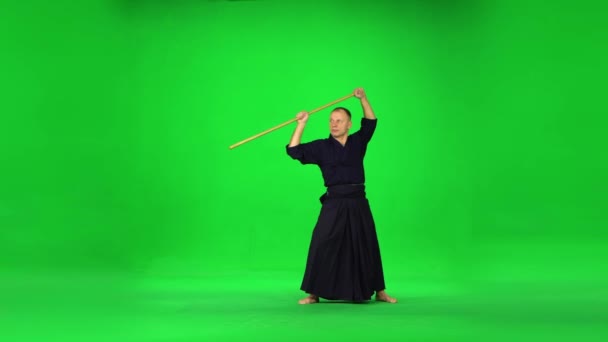 Mužský Kendo bojovník cvičit bojové umění s bambusovým bokken na zelené obrazovce. — Stock video