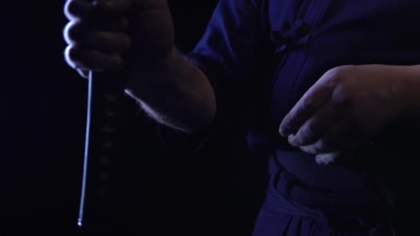 A close-up shot of a ninja mans hand holding a sword and raising it. — Stock Video