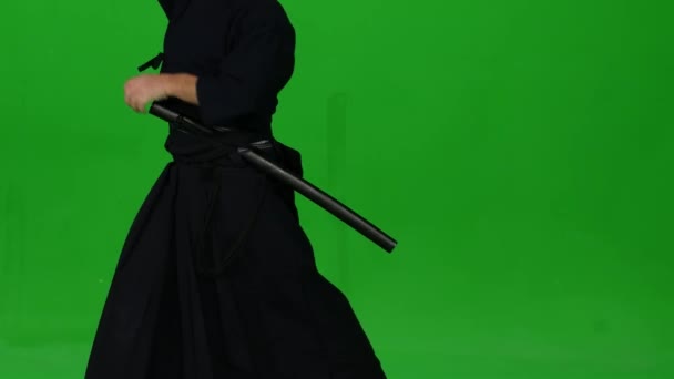 Männliche Kendo-Kriegerin, die Kampfkunst mit dem Bambusbokken auf grünem Bildschirm praktiziert. Nahaufnahme — Stockvideo