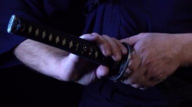 Samuray kılıcı tutan adamın dramatik bir stüdyo resmi. Kapat.