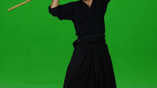 Masculine Kendo warrior practicing martial art with the bamboo bokken on green screen. CLose up — Stock Video