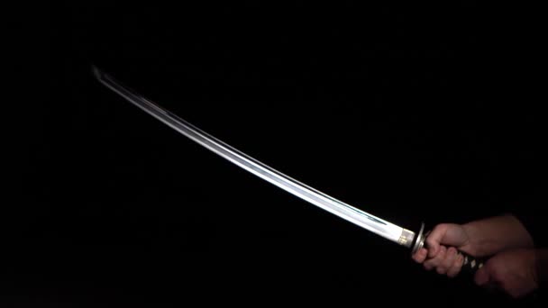 Katana in hand close-up black background — Stock Video