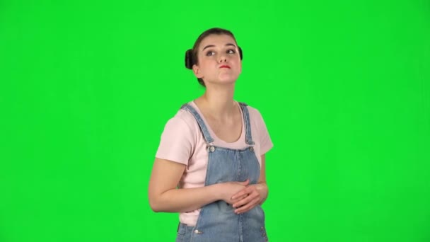 Молодая женщина стоит в ожидании со скукой на зеленом экране — стоковое видео