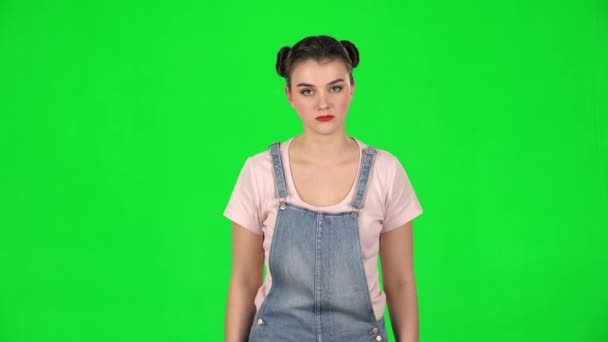 Dívka naštvaný zakrývá její uši s rukama na zelené obrazovce ve studiu — Stock video