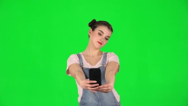Κορίτσι κάνει selfie στο κινητό τηλέφωνο, στη συνέχεια, κοιτάζοντας φωτογραφίες στην πράσινη οθόνη — Αρχείο Βίντεο