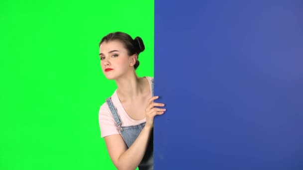 Vrouw kijken uit van achter blauw blanco bordje en roept naar zichzelf wijzen vinge — Stockvideo