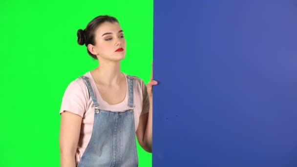 Kvinna tittar ut bakifrån blått tomt plakat ser på honom och skakar huvudet ogillande — Stockvideo