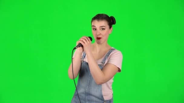 Pretty girl sings into a microphone and moves to the beat of music — Stock Video