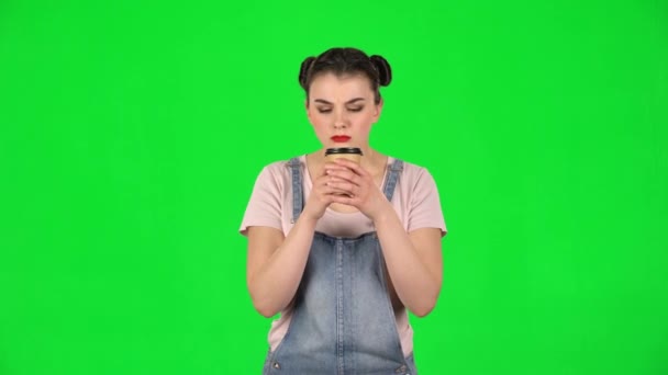 Девушка пьет неприятный кофе и отвратительно на зеленом экране — стоковое видео