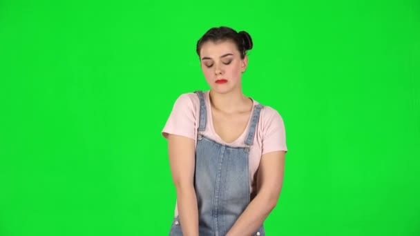 Дівчина дивиться засмучена на камеру і кусає губи зеленим екраном на студії . — стокове відео