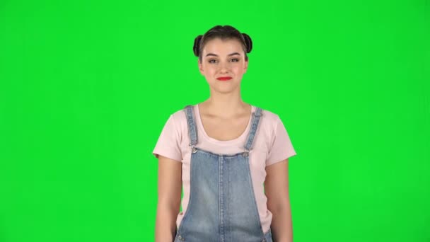 Yeşil ekranda iki saç teli olan gülümseyen kızın portresi. — Stok video