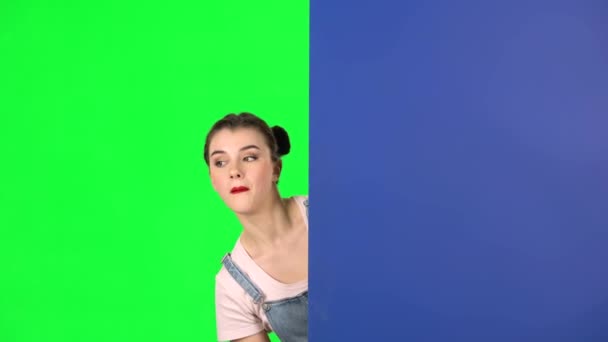 Жінка, дивлячись ззаду блакитного порожнього плакату і закликає до себе вказуючий шар — стокове відео