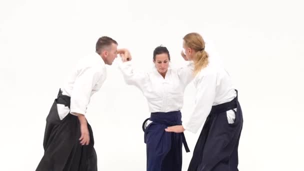 Two males and female demonstrating aikido techniques, isolated on white. Close up — Stock Video
