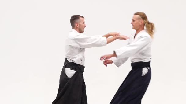 Kimonolu iki adam aikido teknikleri uyguluyor, beyazlar üzerinde izole edilmiş. Kapatın. Yavaş çekim. — Stok video