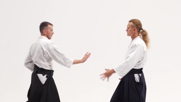 Δύο τύποι με κιμονό να επιδεικνύουν τεχνικές αϊκίντο, απομονωμένοι στα λευκά. Κλείσε. Αργή κίνηση. — Αρχείο Βίντεο