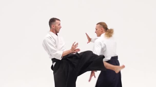 Kimonolu iki adam aikido teknikleri uyguluyor, beyazlar üzerinde izole edilmiş. Kapatın. Yavaş çekim. — Stok video