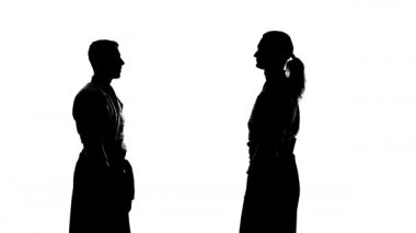 Keikogi ya da kimono giymiş iki erkeğin siyah siluetleri aikido tekniklerini gösteriyor. İzole edilmiş, beyaz. Ağır çekim. Kapat..