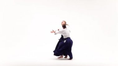 Beyaz keikogi giymiş erkek ve kadın aikido teknikleri gösteriyor, beyazdan izole edilmiş. Yavaş çekim.