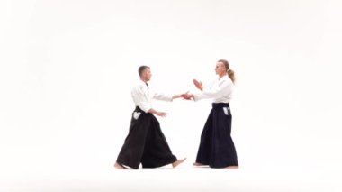 Kimonolu iki adam aikido teknikleri uyguluyor, beyazlar üzerinde izole edilmiş. Yavaş çekim.