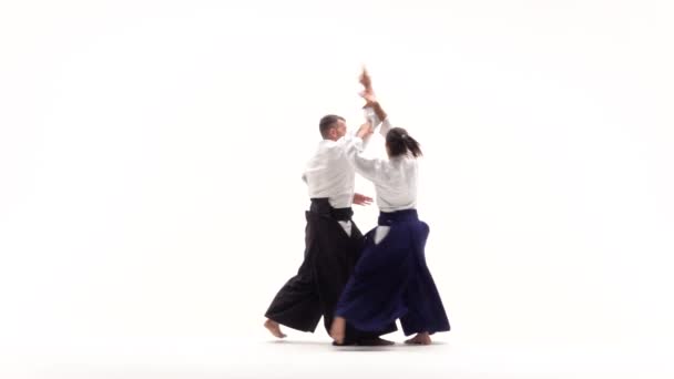 Atleet en vrouw die aikido beoefenen, geïsoleerd op wit. Langzame beweging. — Stockvideo