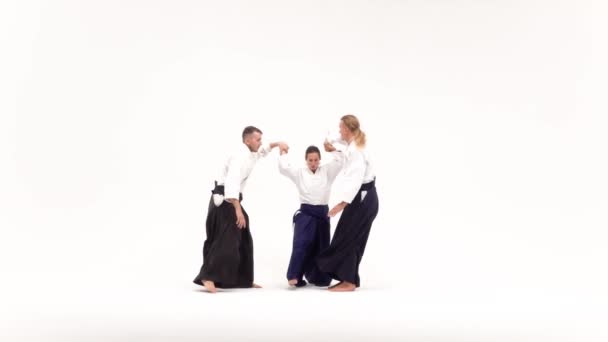 Two males and female demonstrating aikido techniques, isolated on white. Slow motion. — 图库视频影像