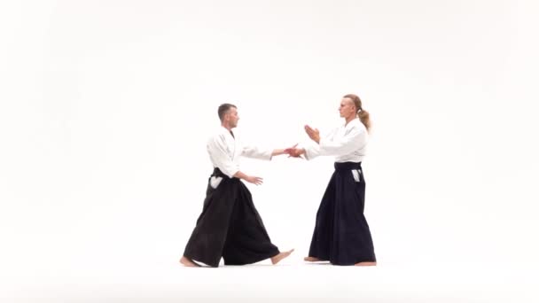 Twee mannen in kimono oefenen aikido technieken, geïsoleerd op wit. Langzame beweging. — Stockvideo