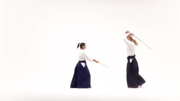 Hombre y mujer practicando aikido usando bokken. Aislado sobre blanco. Movimiento lento . — Vídeos de Stock