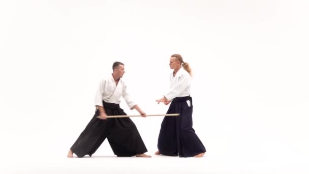 Δύο αθλητές που εκτελούν aikido χρησιμοποιώντας bokken. Απομονωμένος, λευκός. Αργή κίνηση. — Αρχείο Βίντεο