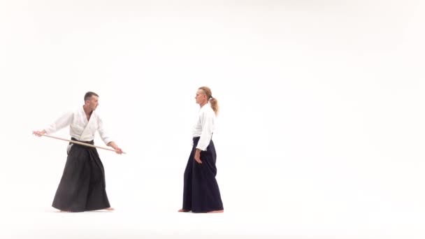 Twee atleten die aikido spelen met bokken. Geïsoleerd, blank. Langzame beweging. — Stockvideo