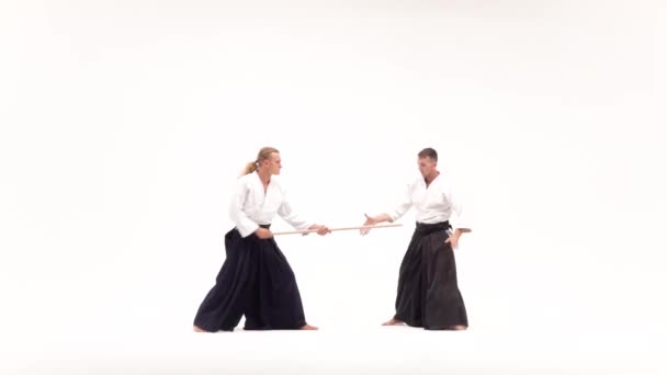 Δύο αθλητές που εκτελούν aikido χρησιμοποιώντας bokken. Απομονωμένος, λευκός. Αργή κίνηση. — Αρχείο Βίντεο