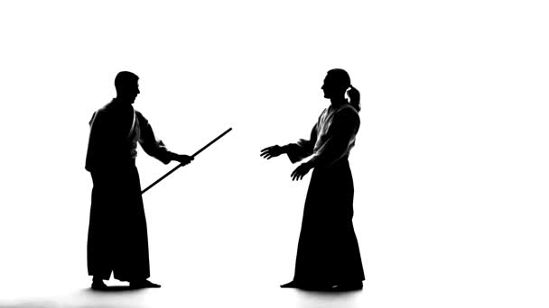 Silhouettes, guys performing aikido using bokken. Isolated, white. Slow motion. — Stock Video