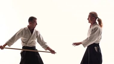 bokken kullanarak aikido yapan iki sporcu. İzole edilmiş, beyaz. Kapatın. Yavaş çekim.