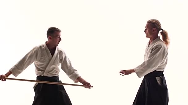 Dua atlet yang tampil aikido menggunakan bokken. Terisolasi, putih. Tutup. Gerakan lambat . — Stok Video