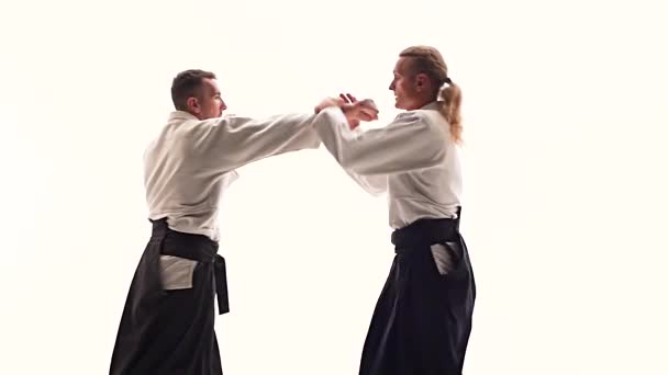 Dos hombres en kimono practicando técnicas de aikido, aislados en blanco. De cerca. Movimiento lento . — Vídeo de stock